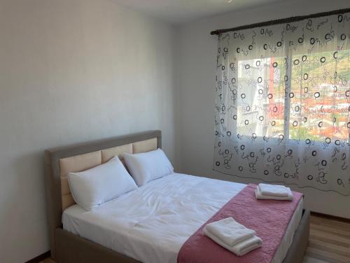 a small bedroom with a bed with a window at LakeView Pogradec in Pogradec
