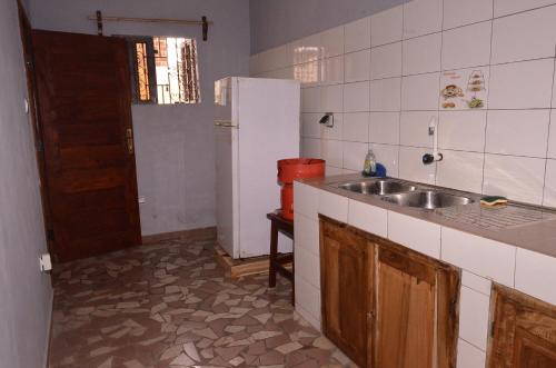 a kitchen with a sink and a refrigerator at Résidence Saint Gall-H in Ouidah