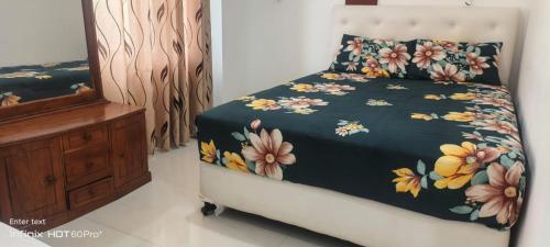 a bedroom with a bed with a floral bedspread at Laya Neem Resort in Dambulla