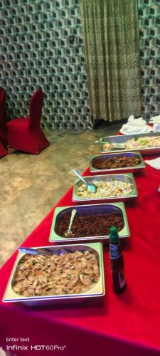 a red table with several trays of food on it at Laya Neem Resort in Dambulla