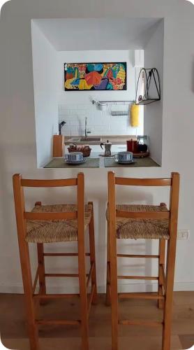 a kitchen with two chairs and a counter with a sink at Casa Lebirann in Bacoli