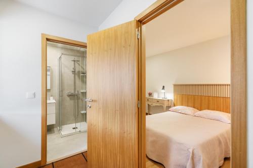 a bedroom with a bed and a walk in shower at Quintinha d´Avó in Vila de Prado