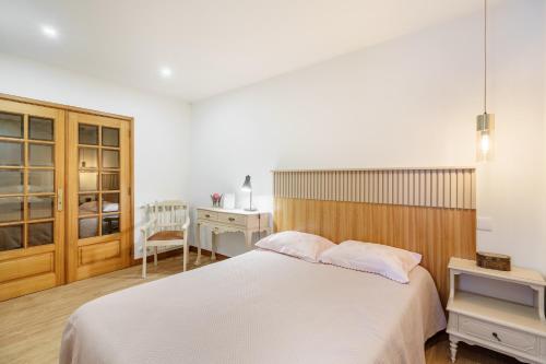 a bedroom with a white bed and a desk at Quintinha d´Avó in Vila de Prado