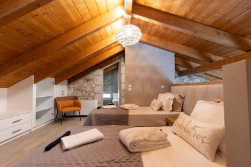two beds in a room with wooden ceilings at Τilevoides Nisi Villas in Spartokhórion