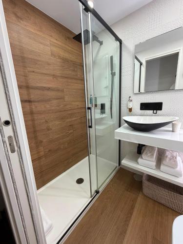 a bathroom with a glass shower and a sink at Hostal San Fernando in Santander