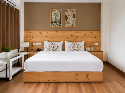 a bedroom with a large white bed and a desk at The Grand Uddhav - a botique hotel in Udaipur