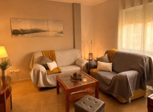 a living room with two chairs and a table at Apartamento Turistico San Cristobal in Plasencia