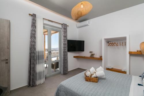 a bedroom with a bed and a tv and a window at Villa Balliu Panorama in Tripiti
