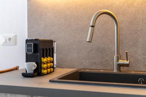 a kitchen counter with a sink with a soap dispenser at Villa Balliu Panorama in Tripiti