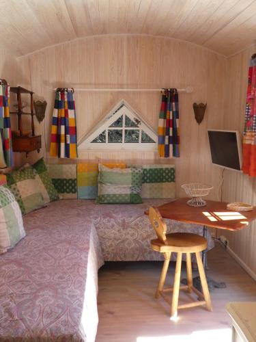a bedroom with a bed and a desk in a room at La Roulotte in Arles