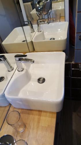 a white sink in a bathroom with two mirrors at La Roulotte in Arles