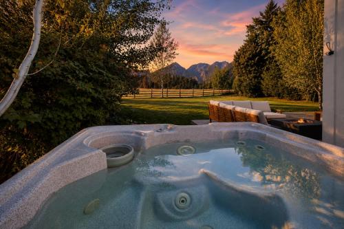 a jacuzzi tub in a yard with a sunset at LeWeber Haus in Leavenworth