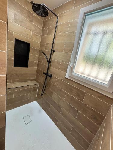 a bathroom with a shower with a window at Maison au calme avec piscine et jardin in BOD