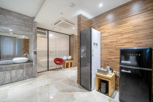 a bathroom with a black refrigerator and a sink at Hotel Airport in Busan