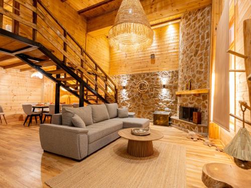 a living room with a couch and a fireplace at Green Olive Luxury Villas in Paliouri
