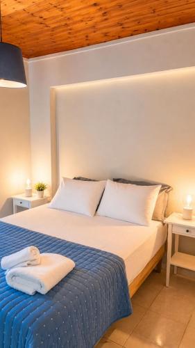 a bedroom with a large bed with a blue blanket at Thelxis Room in Nydri