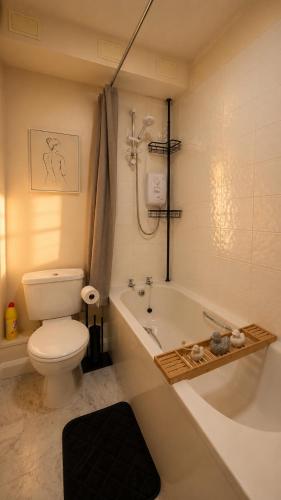 a bathroom with a toilet and a tub and a sink at Cloud Quarters 4 in Huddersfield