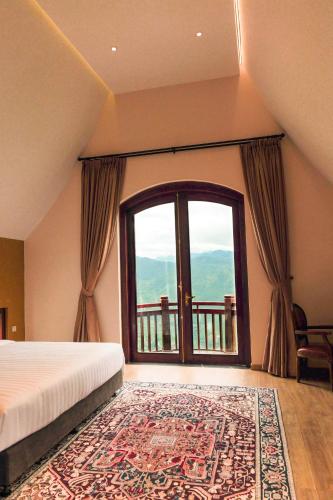 a bedroom with a bed and a large window at ALy's Sapa in Tả Van