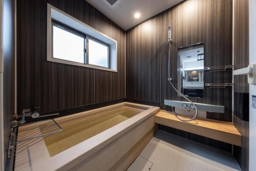 a bath tub in a bathroom with a window at WeskiiHotel in Kanazawa