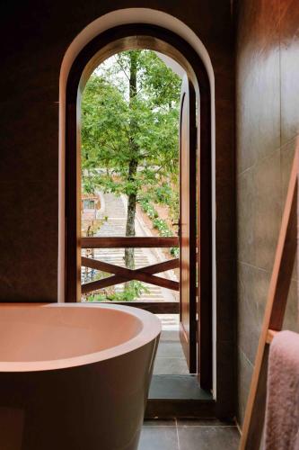 a bathroom with a large window and a bath tub at ALy's Sapa in Tả Van