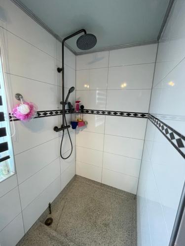 a bathroom with a shower with white tiled walls at SB villa house in Vlissingen