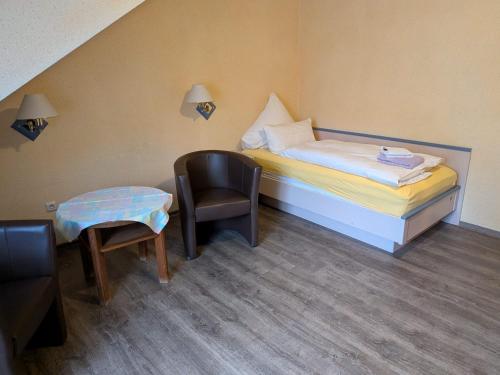 a small room with a bed and a chair at Hansens Zimmervermietung in Handewitt