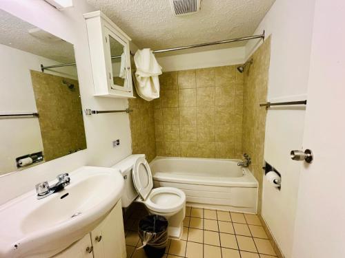a bathroom with a sink and a toilet and a tub at Midtown Inn SSK in Saskatoon