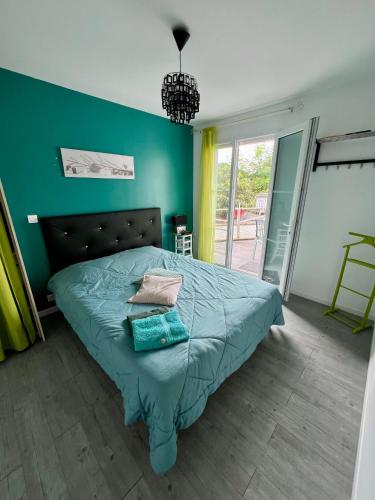 a bedroom with a bed with a green wall at Chez Christelle in Audenge