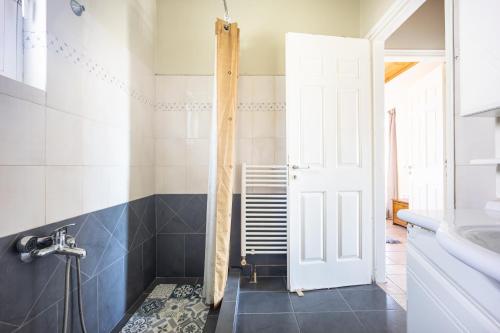 a bathroom with a white door and a sink at Artemis Breeze in Artemida