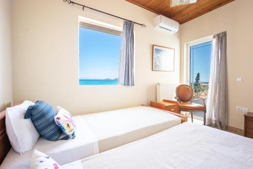 a bedroom with two beds and a window at Artemis Breeze in Artemida