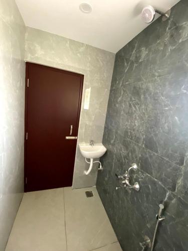 a bathroom with a door and a sink in it at SANTHOSH RESIDENCy in Chengalpattu