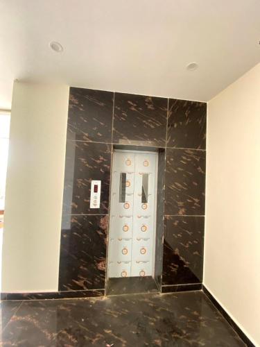 an elevator in a building with black marble walls at SANTHOSH RESIDENCy in Chengalpattu