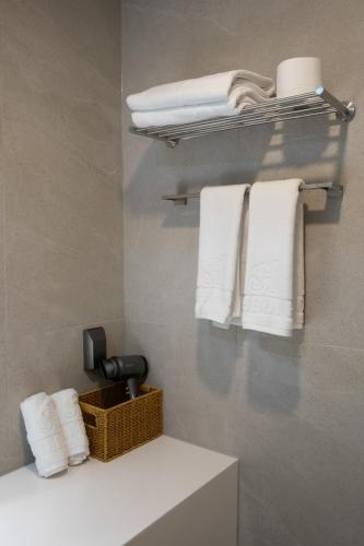 ein Badezimmer mit weißen Handtüchern und einem Handtuchkorb in der Unterkunft Southernheal Hotel in Haenam