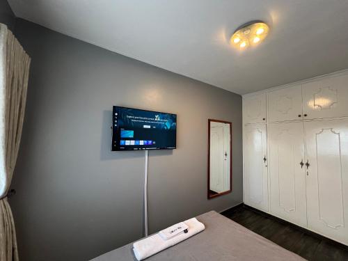 a room with a flat screen tv on the wall at Nduna Legacy Apartment in Harare