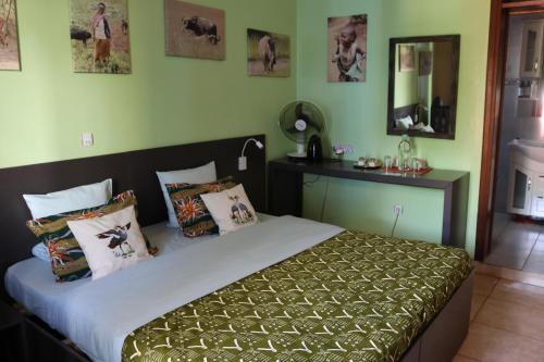a bedroom with a bed with green walls at Umusambi B&B in Kigali