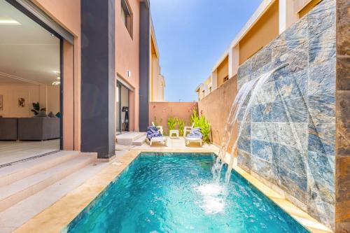 a swimming pool with a waterfall in a house at Villa Horizon Premium - Private Pool - Fully Renovated - Marrakech in Marrakesh