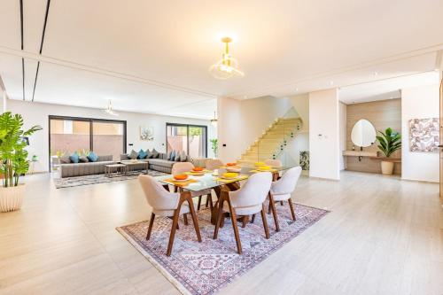 a dining room and living room with a table and chairs at Villa Horizon Premium - Private Pool - Fully Renovated - Marrakech in Marrakesh
