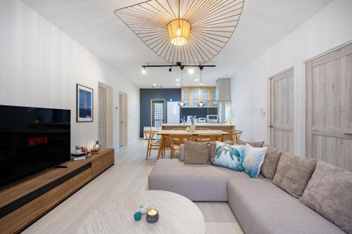 a living room with a couch and a dining room at インギャーラクシー in Miyakojima