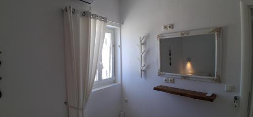 a white room with a mirror and a window at Naxian Scenery in Glinado Naxos
