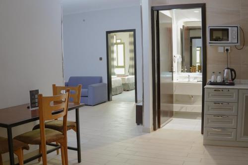 a room with a table and a kitchen with a bathroom at Pherbion Hotel Apartment Abha in Abha
