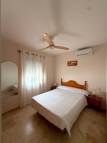 a bedroom with a bed and a ceiling fan at Chalet Matalascañas in Matalascañas