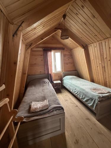 a room with a bed in a wooden cabin at Cloudtop House - Gomismta in Gomi