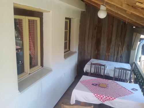 a dining room with two tables and two windows at "Poetsko ćoše" Nikole Tesle 86 in Morović