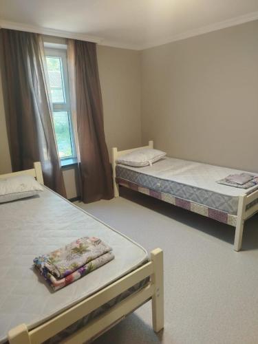 a room with two beds and a window at Istisu in Müqtǝdir