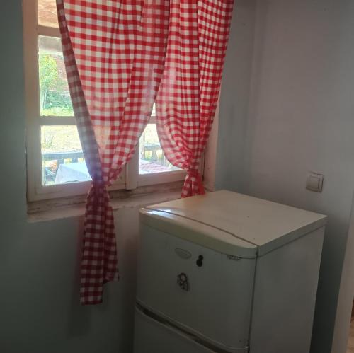 a window with a red and white checkered curtain above a toilet at "Poetsko ćoše" Nikole Tesle 86 in Morović