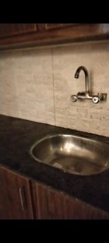 a sink in a kitchen with a black counter top at Hayatabad Heights1 in Peshawar