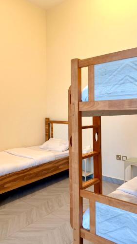 a bunk bed room with two bunk beds and a ladder at In The Peaks in Sharīyah