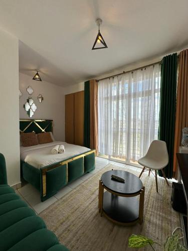a bedroom with a bed and a couch and a table at Ngong Road Luxe Studio in Nairobi