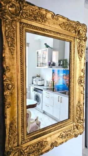 a mirror in a gold frame in a kitchen at Hotel Jugend with Self Check-in in Liepāja