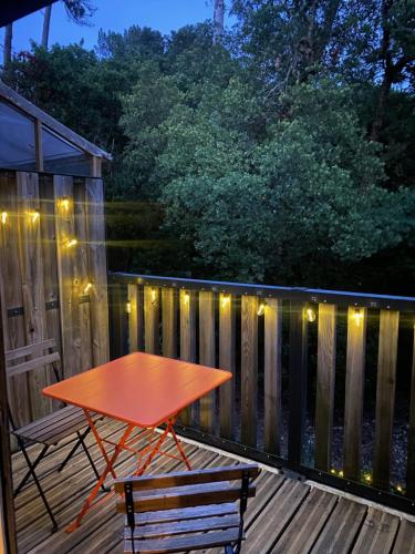a table and two chairs on a deck with lights at Labenne beach apartment in Labenne